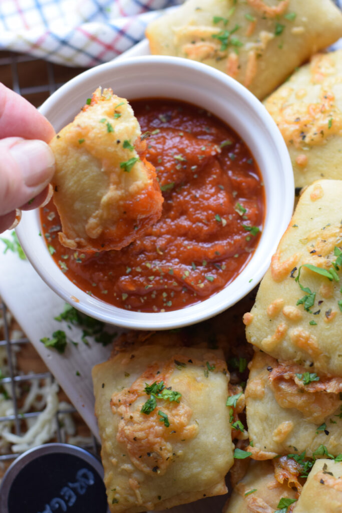 Pizza pockets dipped in pizza sauce.