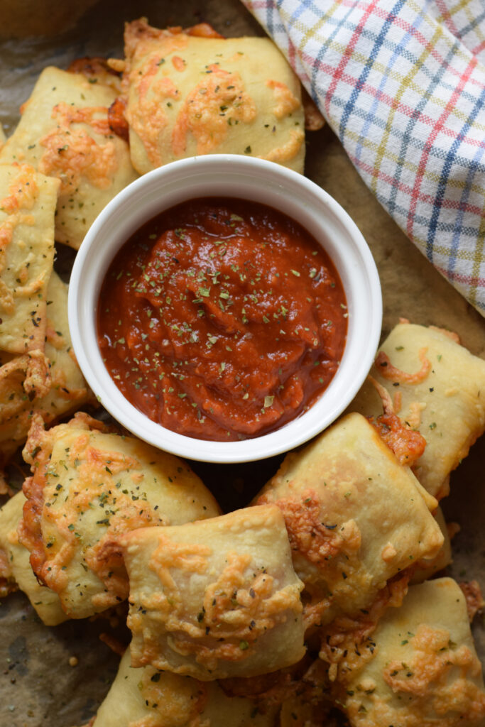Pizza pockets served with pizza sauce.