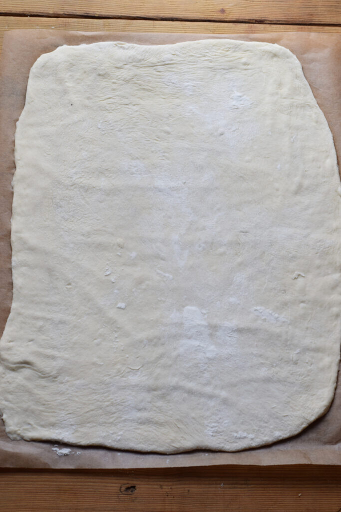 Pizza dough rolled out into a rectangle.