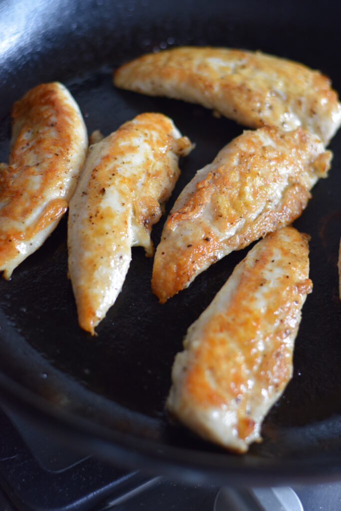 Skillet chicken tenders in a cast iron pan.