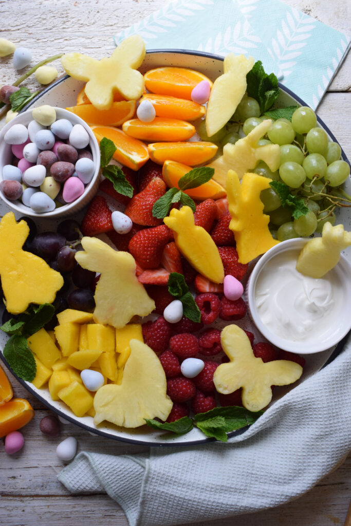 Assembled Easter fruit platter on a white tray.