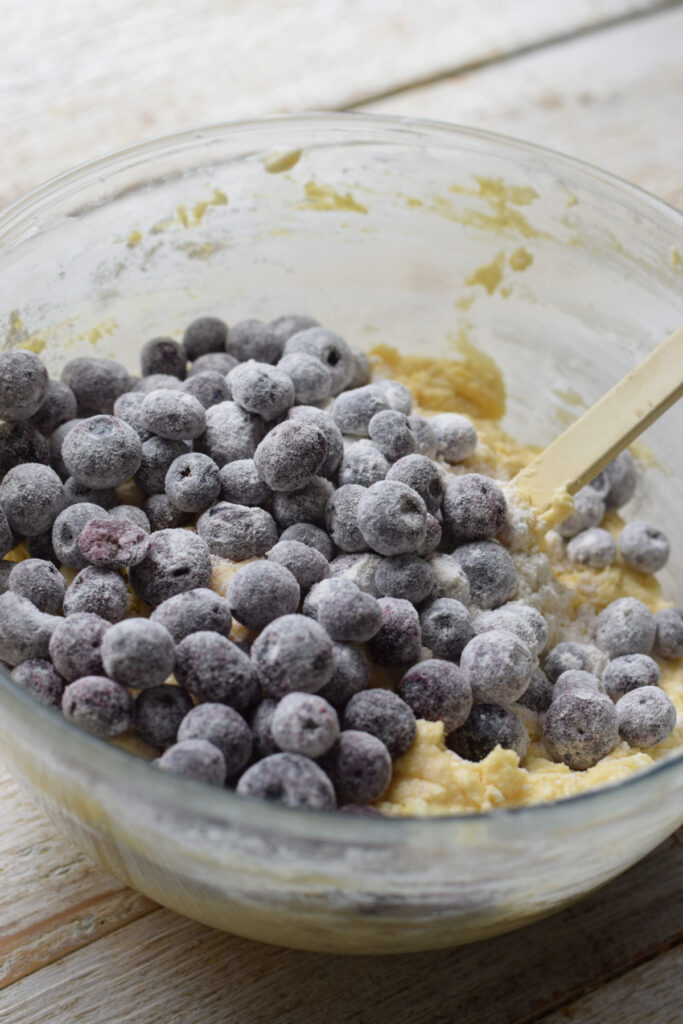 Adding blueberries to cake batter.