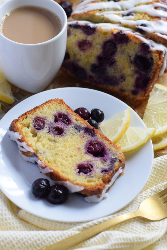 A slice of lemon blueberry loaf with a cup of tea.