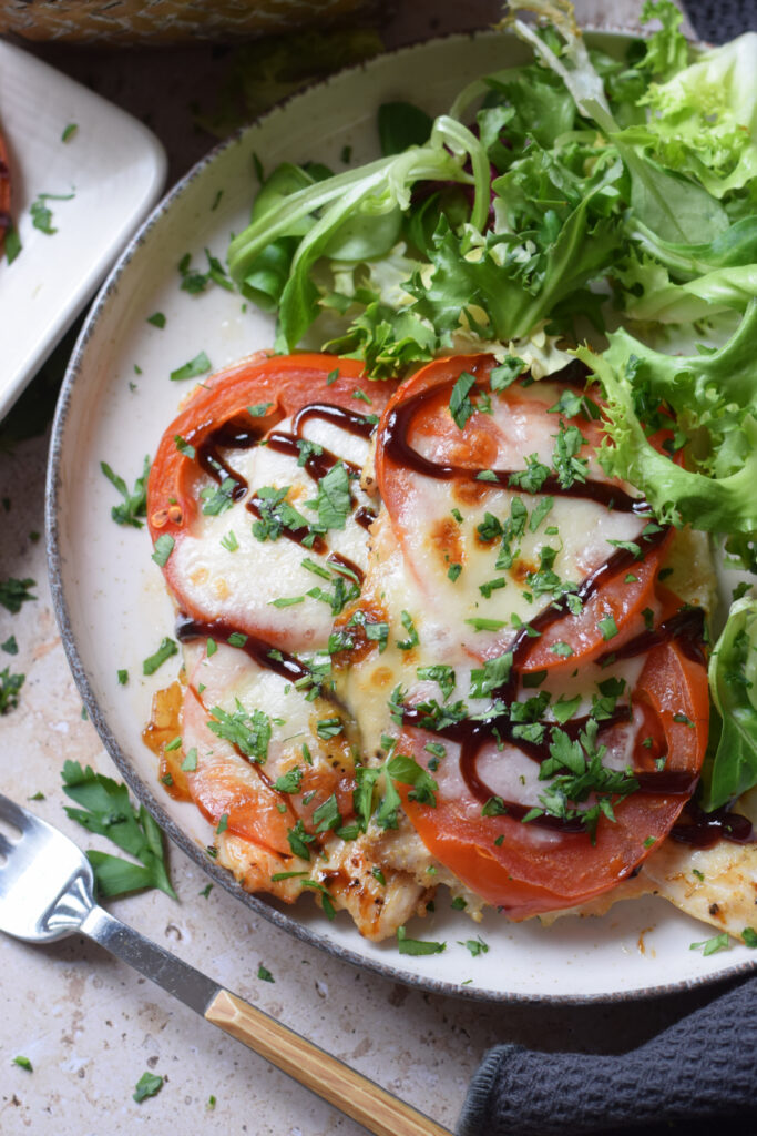 Tomato and mozzarella chicken on a plate.
