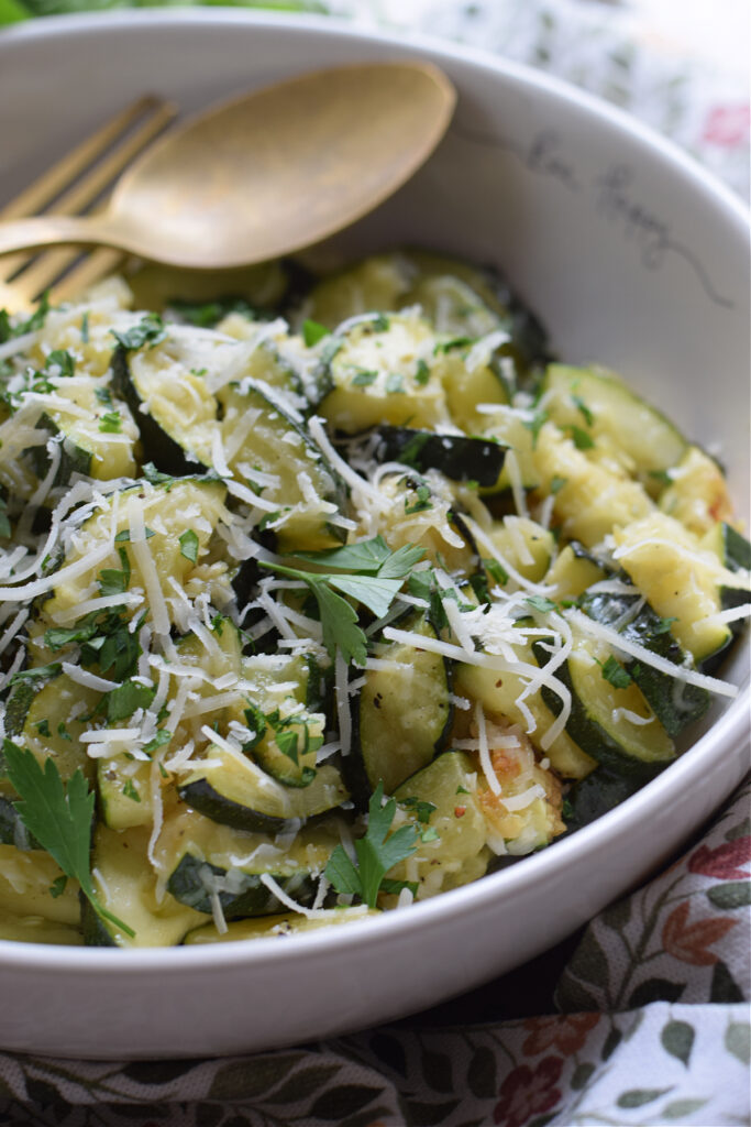 Close up of zucchini in a bowl  with parmesan cheese.