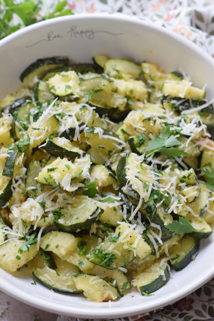 Close up of zucchini in a bowl with parmesan cheese.
