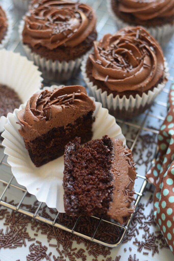 Chocolate frosted cupcakes on a baking tray.
