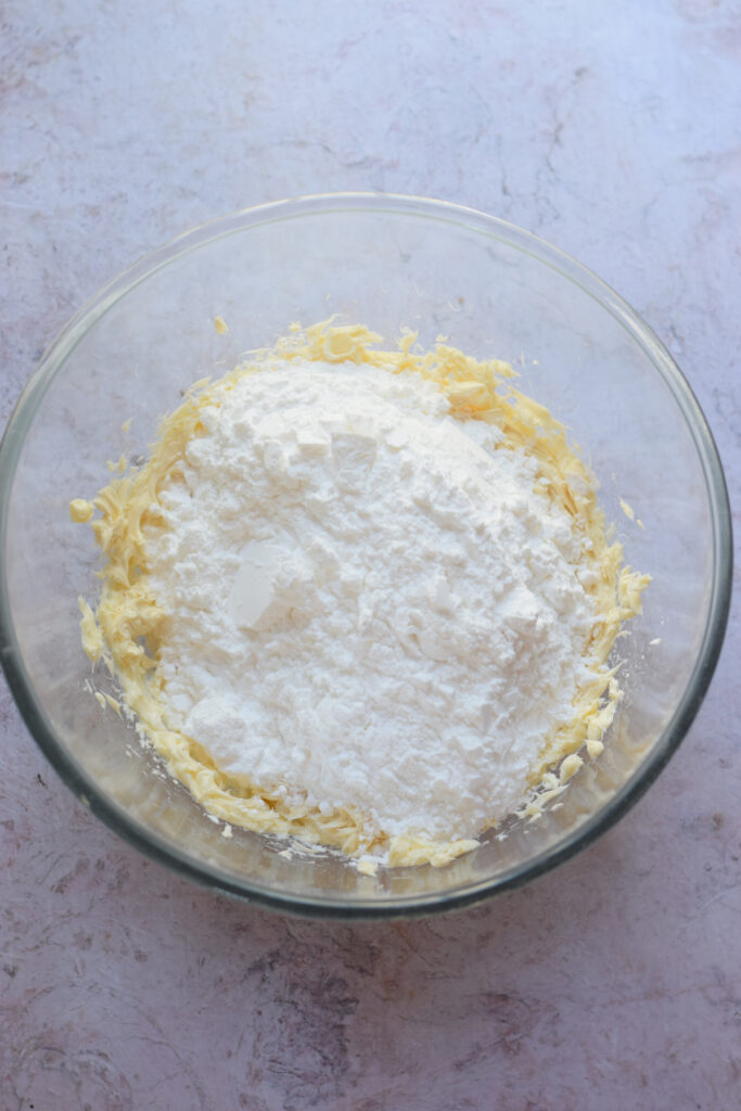 Add powdered sugar to whipped butter.