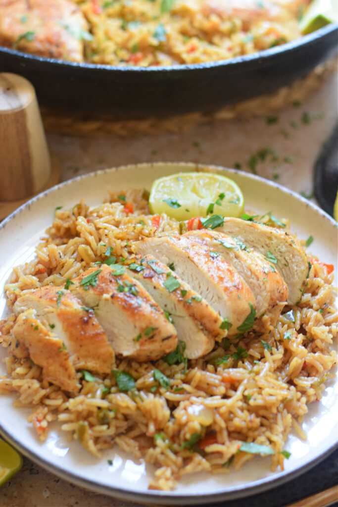 Close up of sliced chicken breast on a bed of spiced rice.