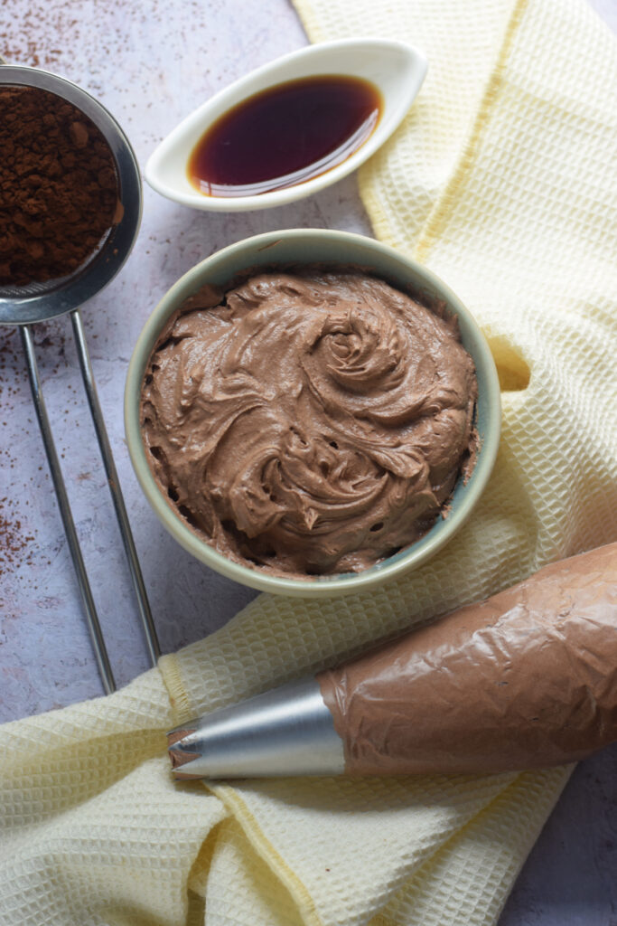 Chocolate buttercream frosting in a small bowl.