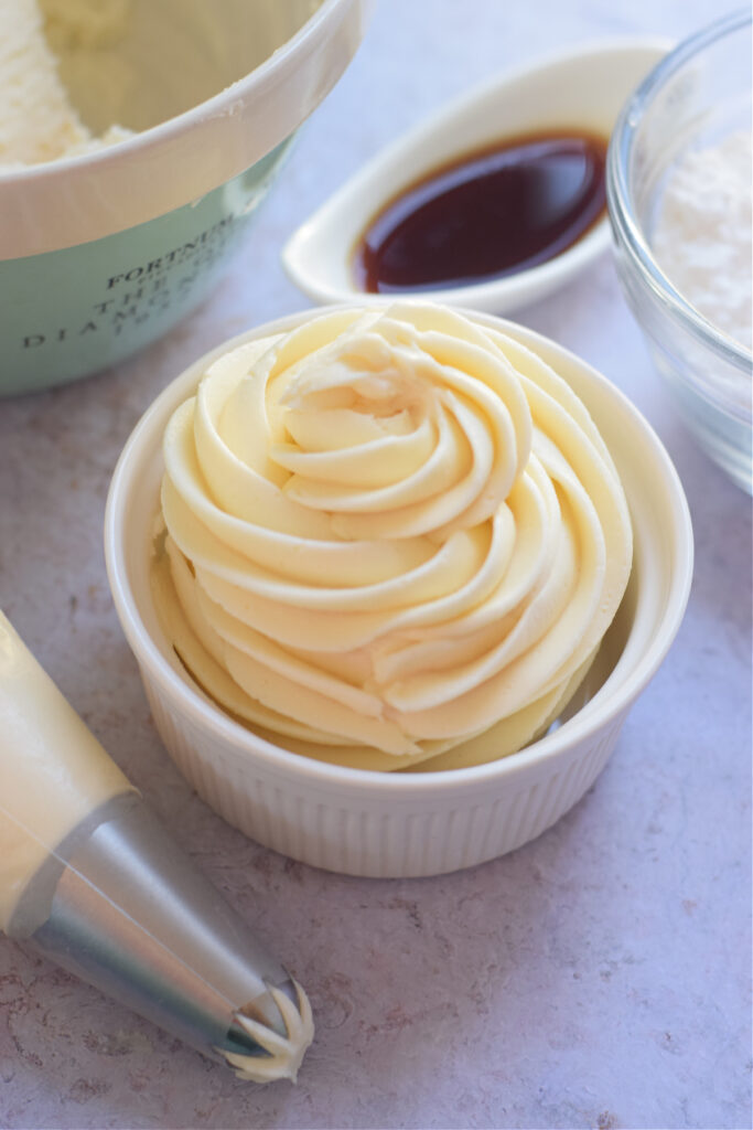 Whipped vanilla buttercream frosting in a small bowl.