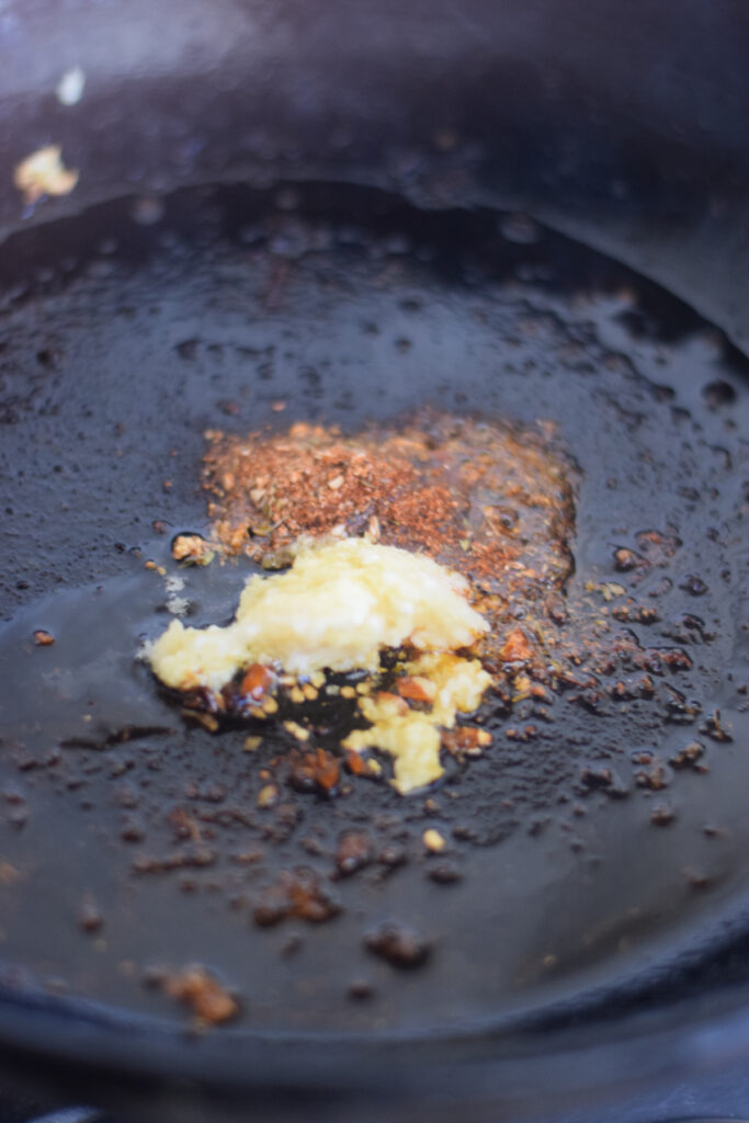 Close up of garlic and spices in a skillet.