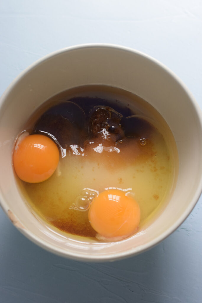 Eggs, oil and sugar in a mixing bowl.