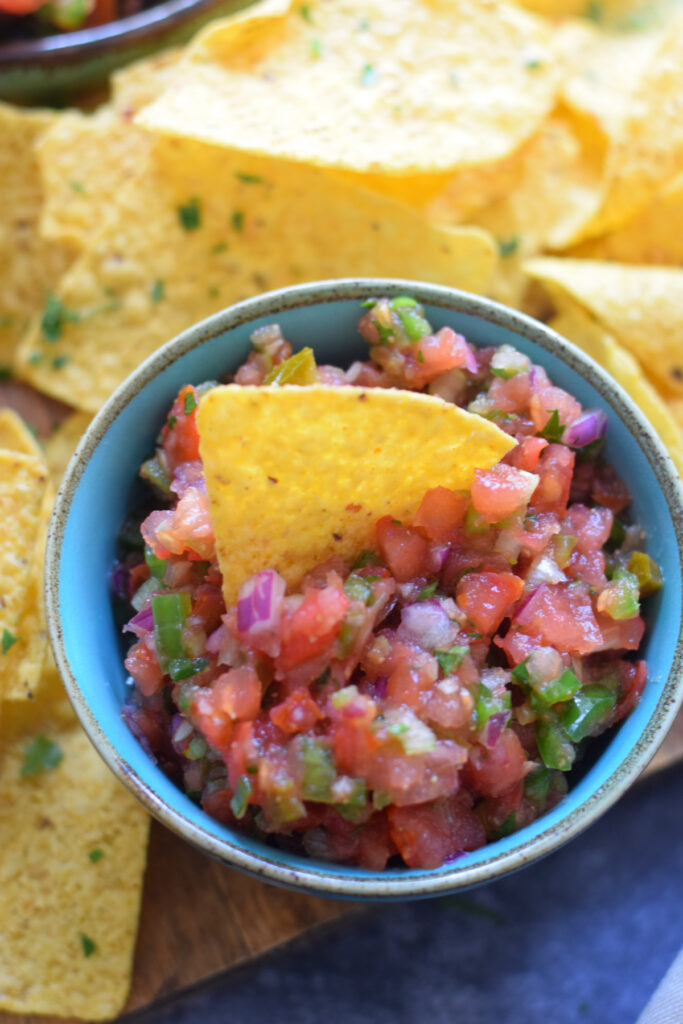 Homemade salsa in a small bowl with tortilla chips.