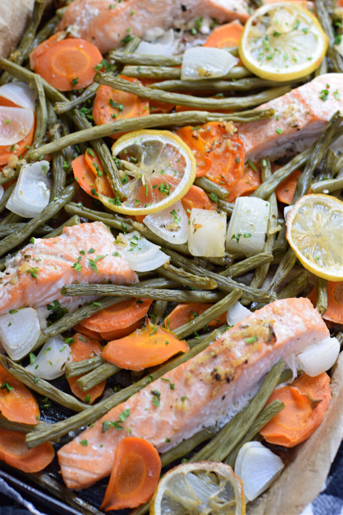 Cooked salmon and vegetables on a baking tray.