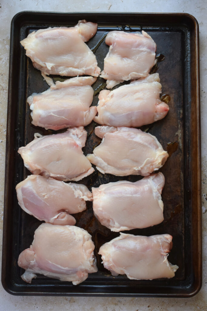 Chicken thighs on a baking tray ready to bake.