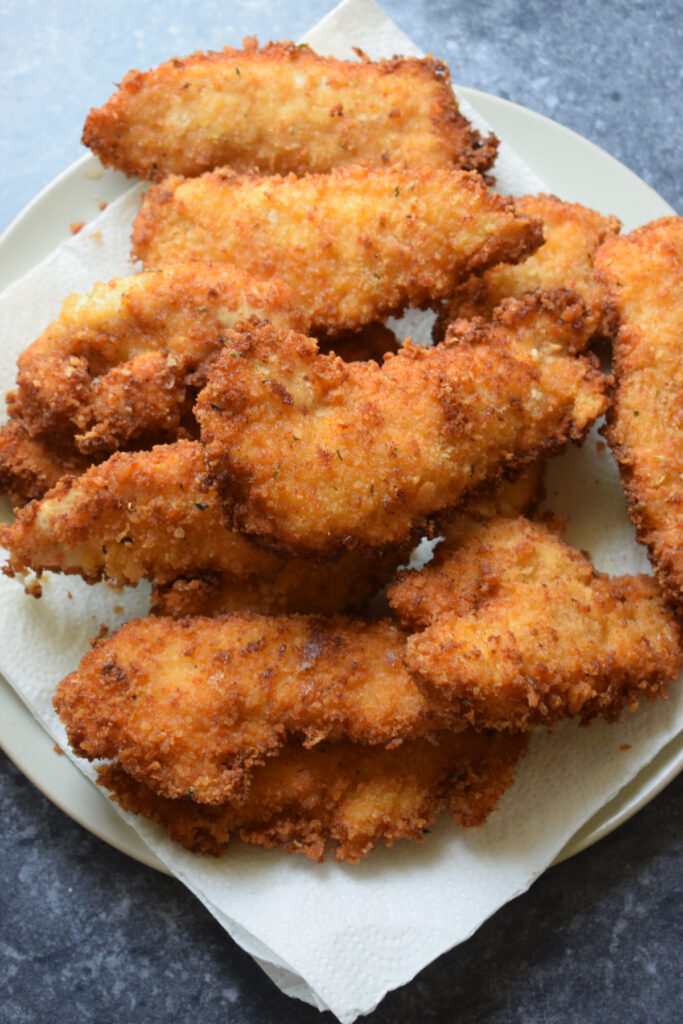 Cooked chicken tenders on paper towels.