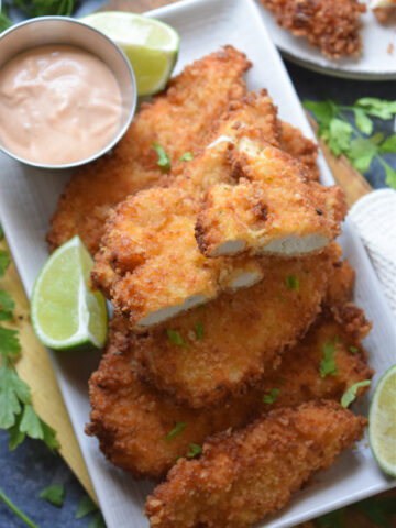 Panko crusted chicken tenders on a plate.