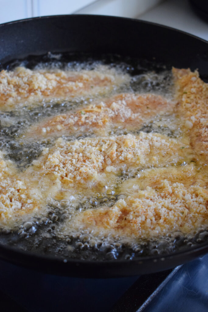 Cooking chicken tenders in oil.