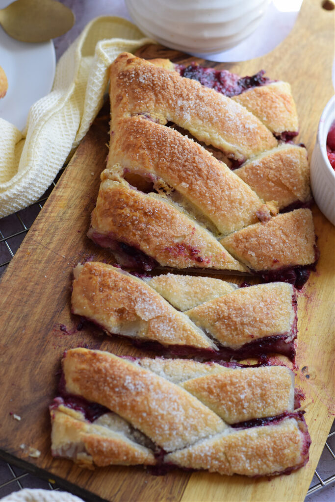 Mixed berry danish on a wooden board.