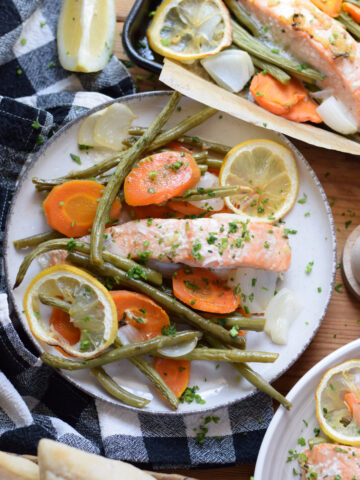 Salmon with vegetables on serving plates.