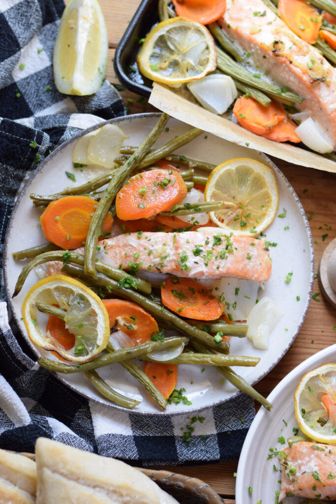 Salmon with vegetables on serving plates.