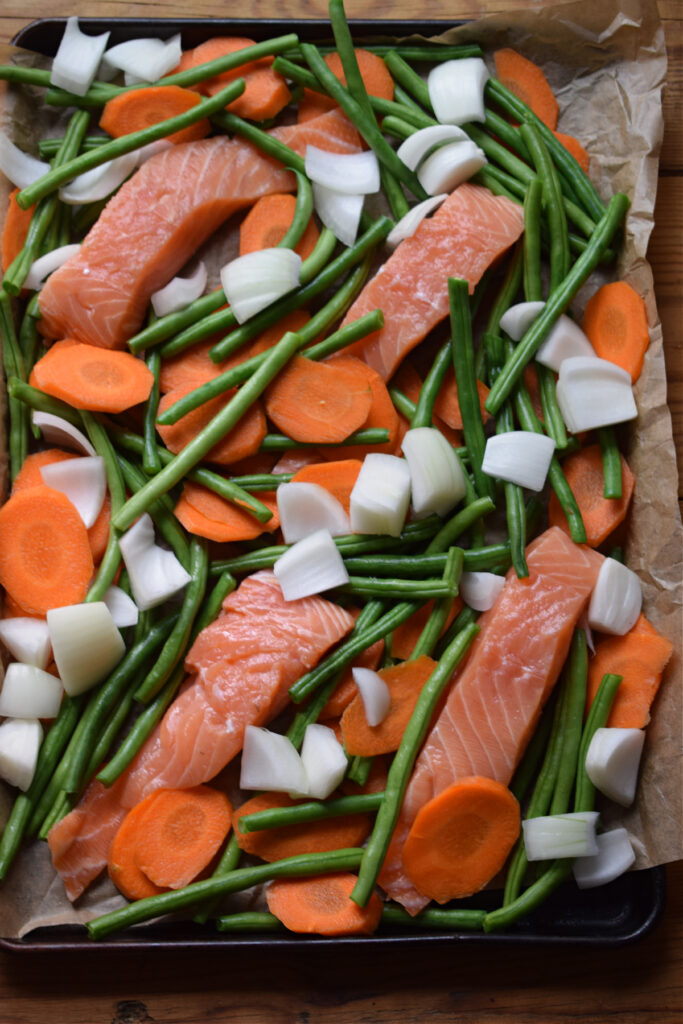 Salmon and vegetables on a large baking tray.