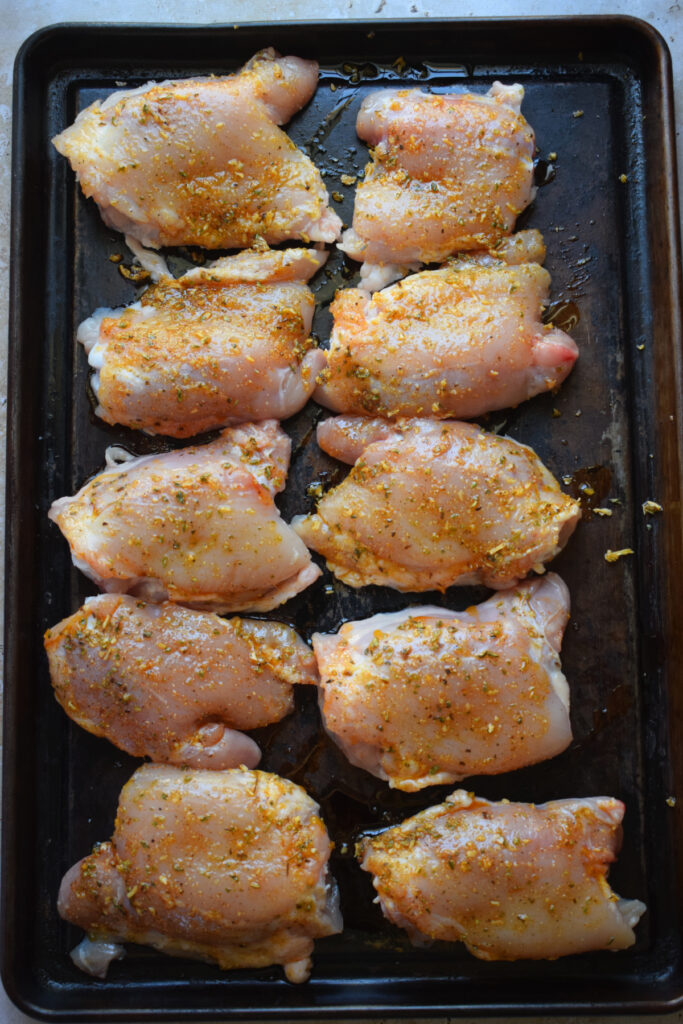 Ready to bake chicken thighs on a baking sheet.