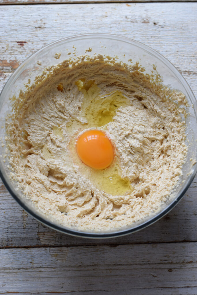 Adding eggs to cookie batter.