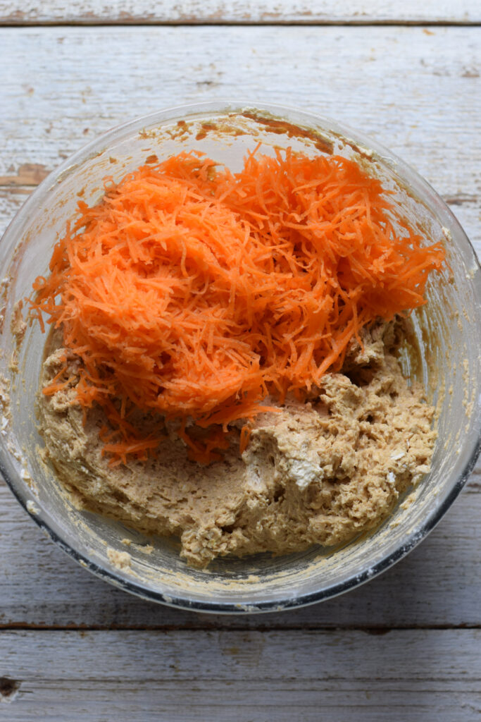 Adding grated carrots to cookie dough.