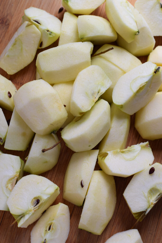 Apples cut into quarters on a board.