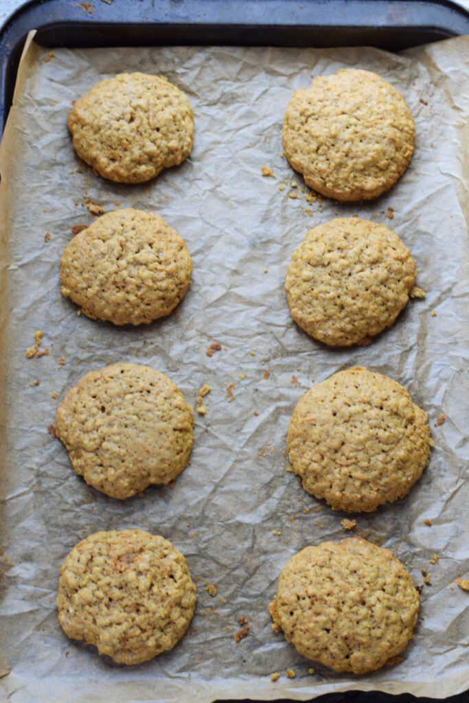 Baked carrot cake cookies on a baking tray.