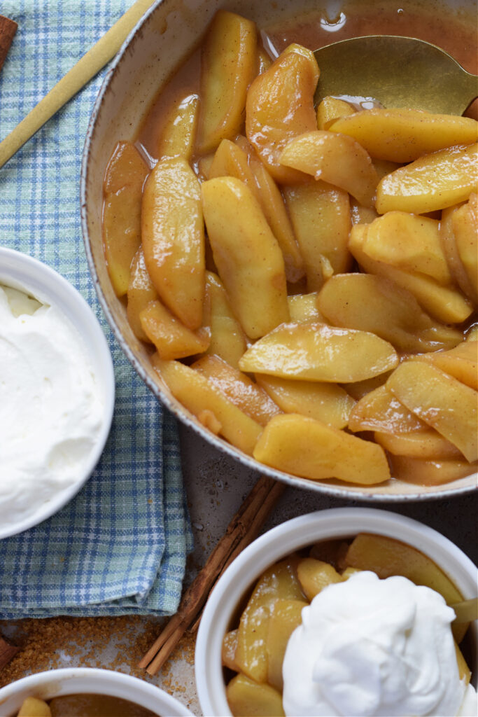 Apples in a bowl with cream on the side.