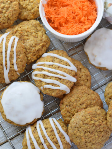 Carrot cake cookies on a rack with grated carrots.