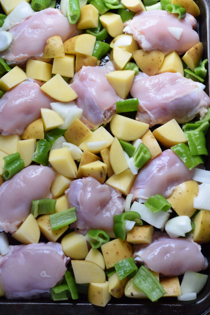 Chicken and vegetables on a baking tray.