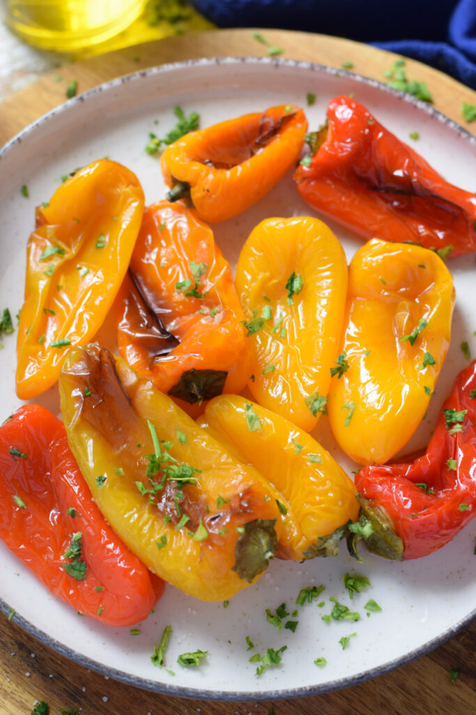 Close up of roasted mini peppers on a plate.