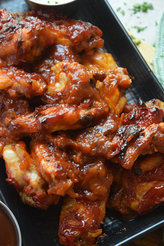 Close up of chicken wings covered with barbecue sauce.