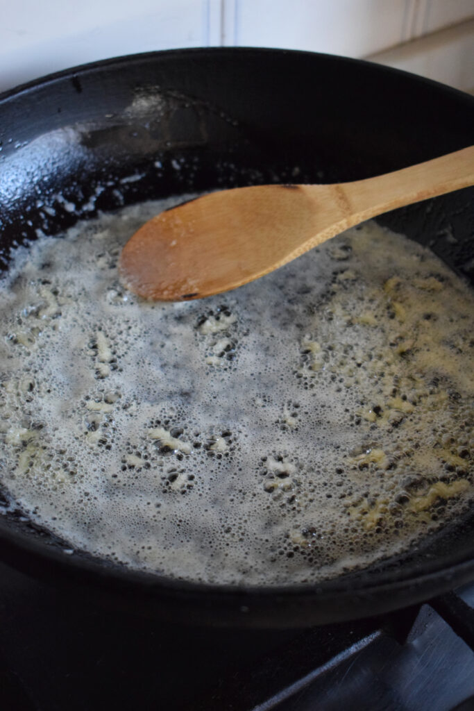 Cooking butter and garlic in a skillet.