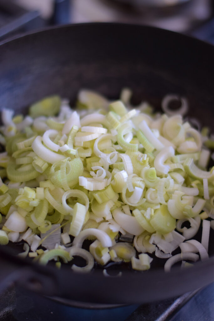 Cooking leeks in a skillet.