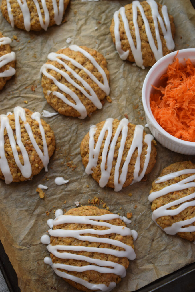 Glazed carrot cake cookies on a baking tray.