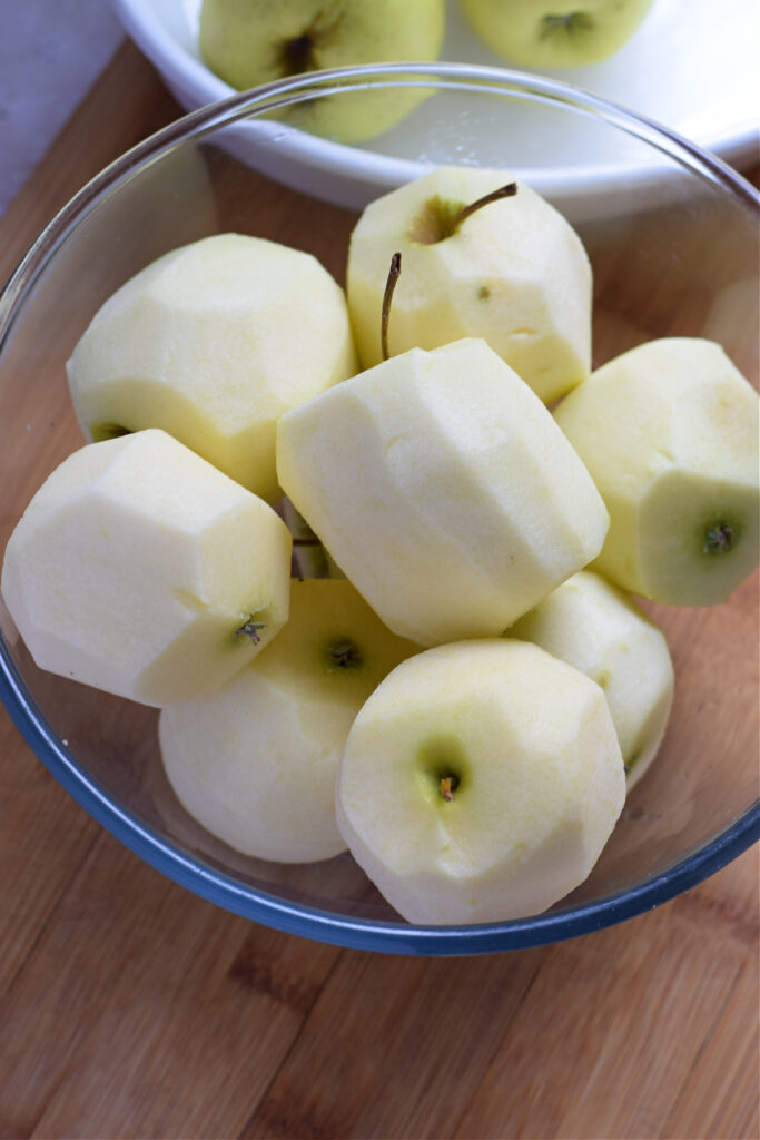 Peeled apples in a glass bowl.