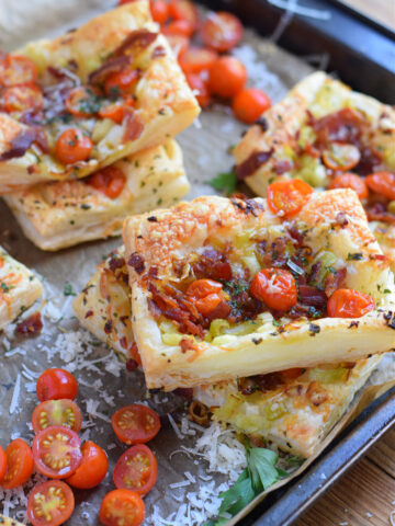 Puff pastry tomato and bacon tarts on a tray.