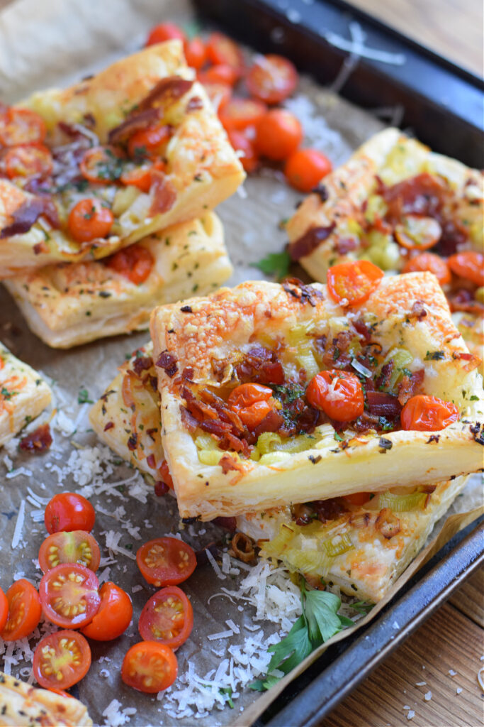 Puff pastry tomato and bacon tarts on a tray.