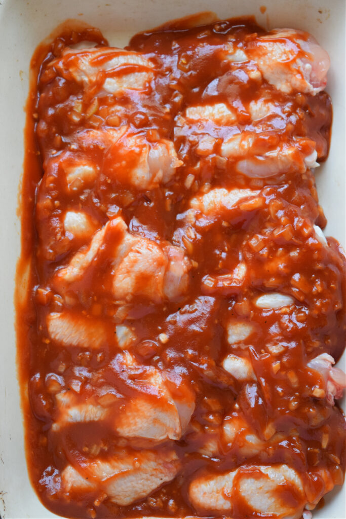 Chicken wings smothered in barbecue sauce ready to bake.