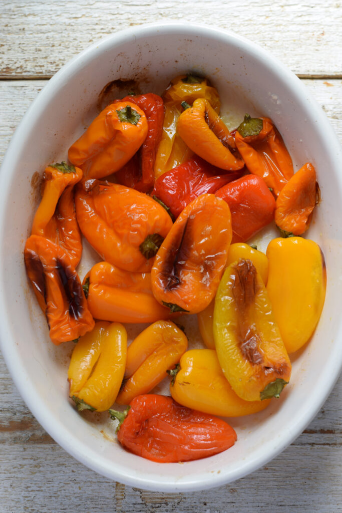 Roasted sweet mini peppers in a white dish.