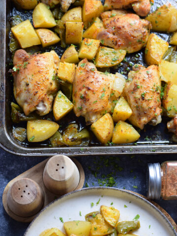 Chicken thighs and potatoes on a serving tray.