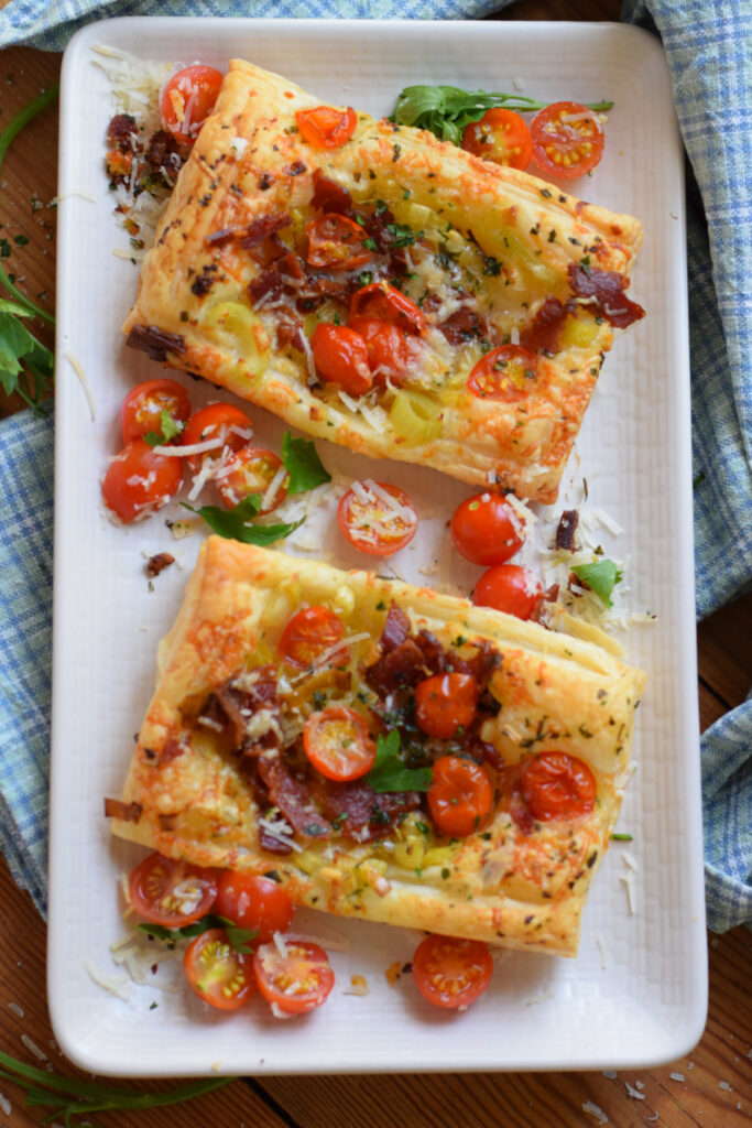 Puff pastry tomato tarts on a white plate.