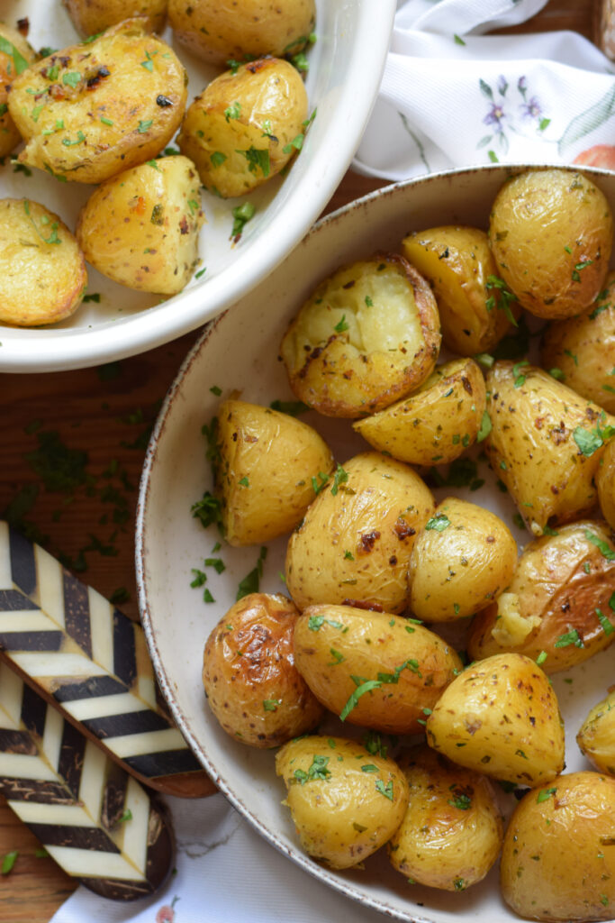 Golden roasted potatoes with serving dishes.