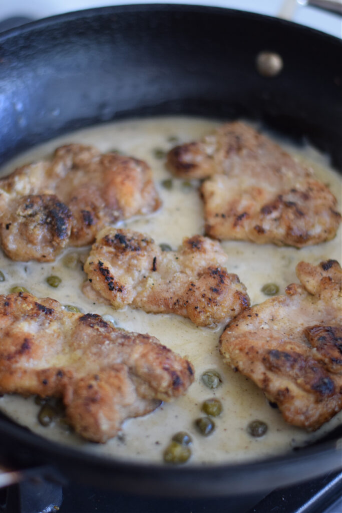 Cooking chicken in a cream caper sauce.