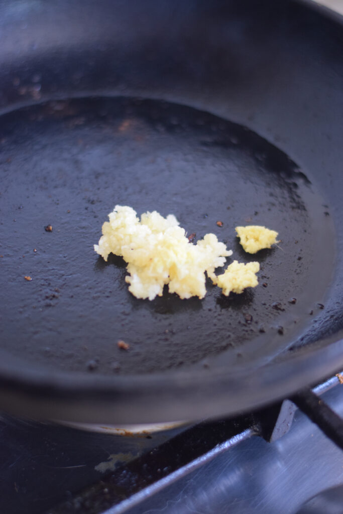 Cooking garlic and ginger in a large skillet.